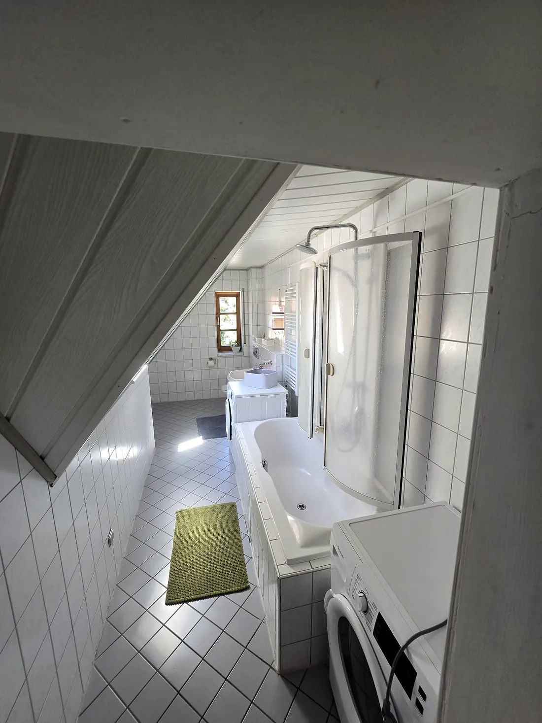 Badezimmer in Wohnung 1 mit Badewanne, Dusche und Waschmaschine