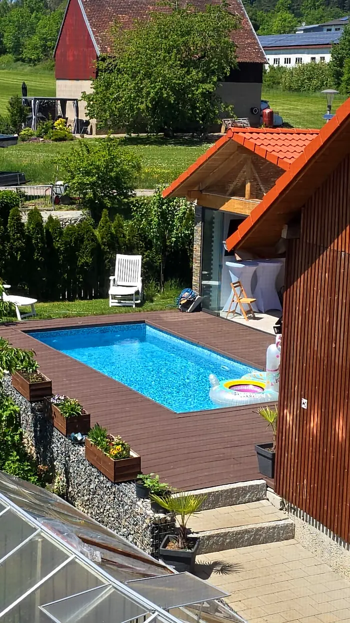 Blick von oben auf den beheizten Pool und die Holzterrasse